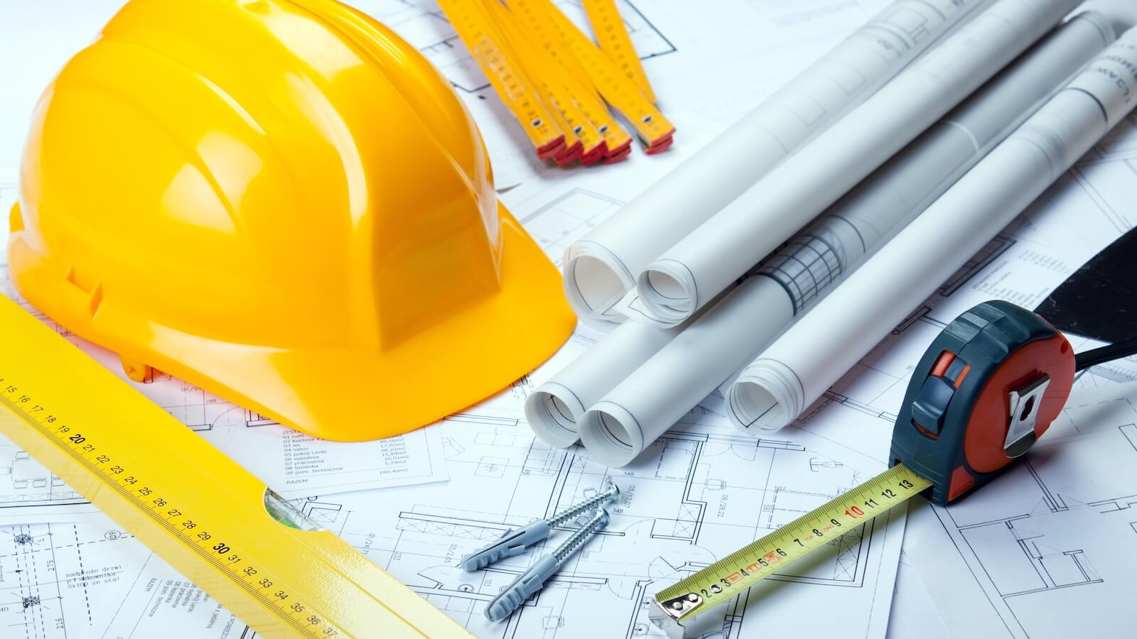 Construction materials hard hat, measuring devices nails, plans