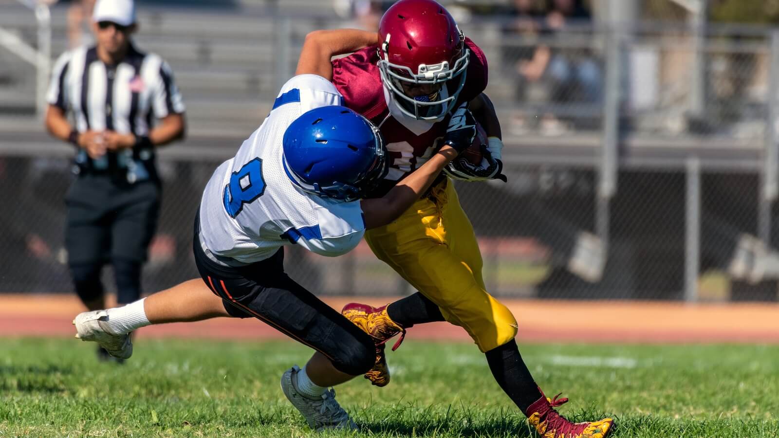 Defensive player tackling offensive running back